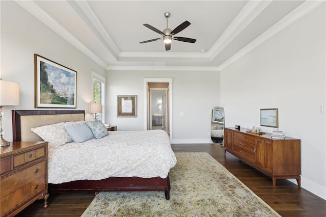 bedroom featuring a tray ceiling, baseboards, and dark wood-type flooring