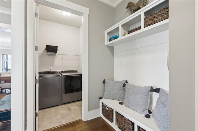 mudroom featuring washing machine and clothes dryer, baseboards, and dark wood-style floors