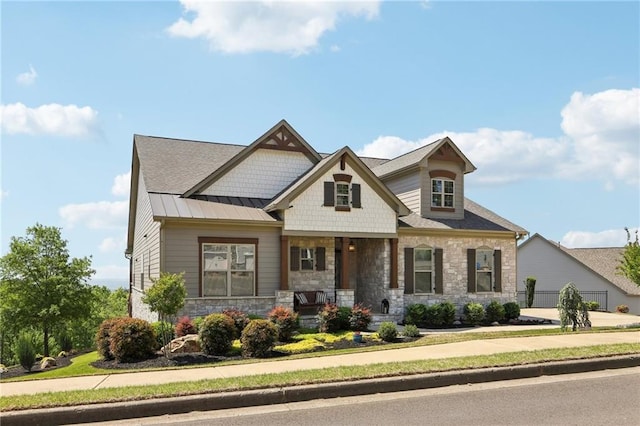 craftsman-style home with a porch, a standing seam roof, and stone siding