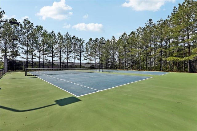 view of tennis court featuring fence and community basketball court