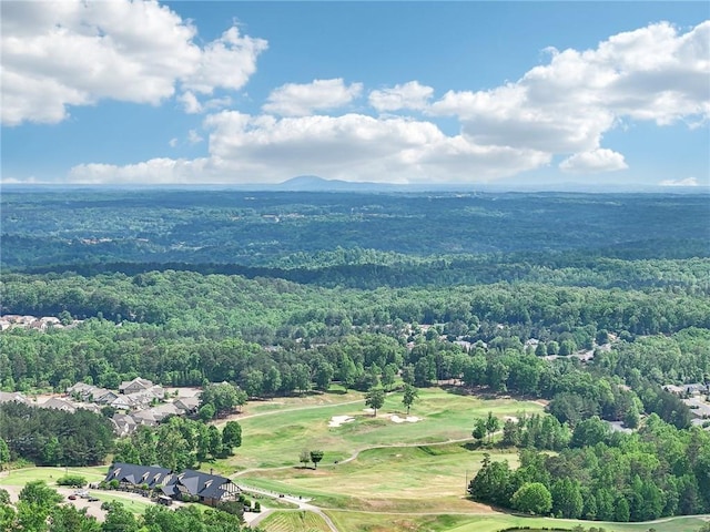 drone / aerial view featuring golf course view and a wooded view