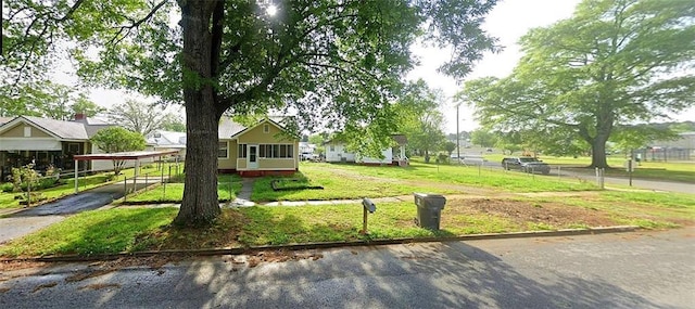 exterior space featuring a carport, a lawn, and fence