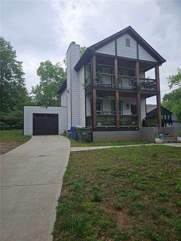 1228 Ladd St SW, Atlanta, GA 30310 - view of front of property featuring a garage, driveway, a chimney, and a balcony