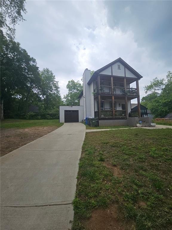1228 Ladd St SW, Atlanta, GA 30310 - view of front of house featuring driveway, a garage, a balcony, and a front yard