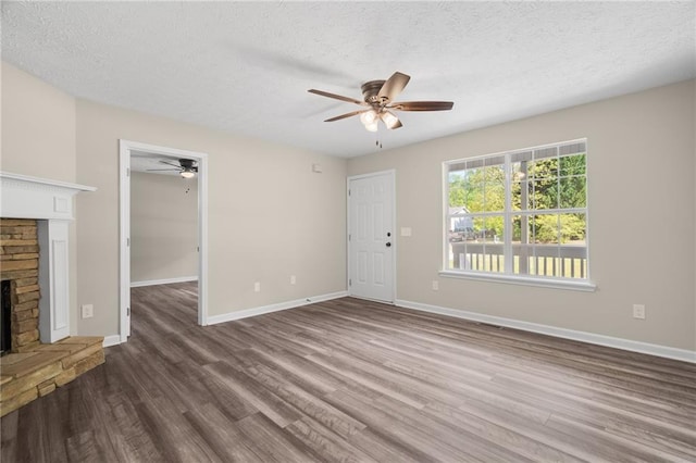201 Rustin Dr, Dallas, GA 30157 - unfurnished living room with baseboards, a ceiling fan, a fireplace with raised hearth, and wood finished floors