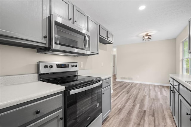 201 Rustin Dr, Dallas, GA 30157 - kitchen featuring light countertops, stainless steel appliances, gray cabinetry, and light wood-type flooring