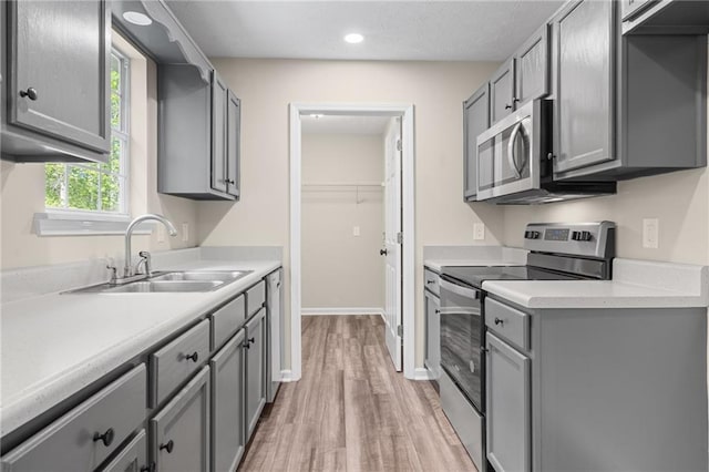 201 Rustin Dr, Dallas, GA 30157 - kitchen with light countertops, gray cabinets, a sink, light wood-style flooring, and appliances with stainless steel finishes