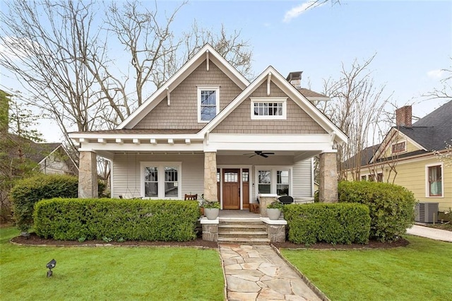 view of front of house featuring central air condition unit, a chimney, a front lawn, and a porch