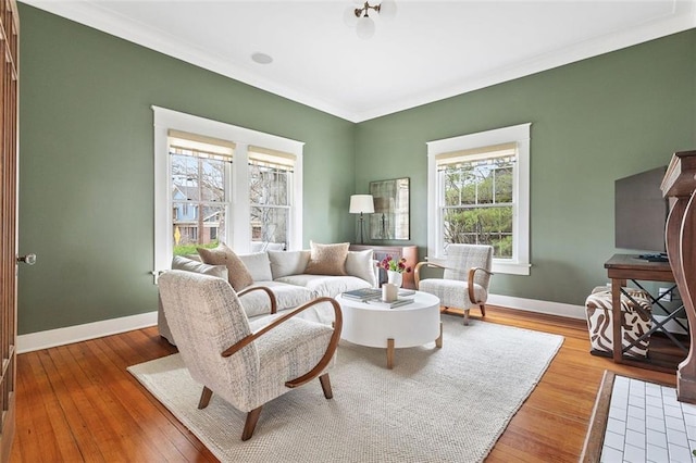 living area with crown molding, baseboards, and hardwood / wood-style flooring