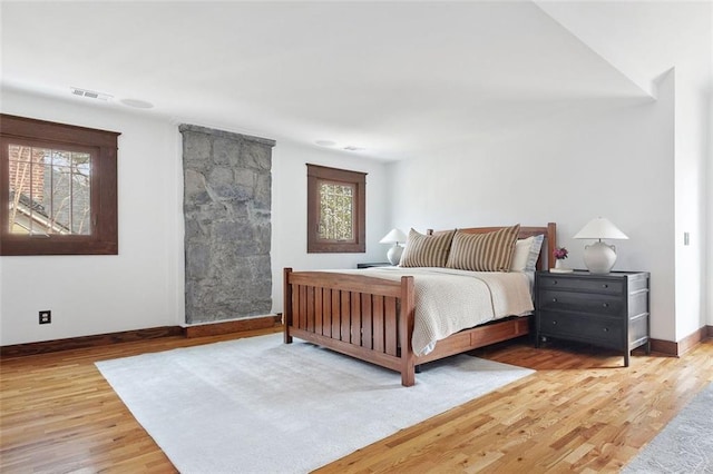 bedroom featuring baseboards, visible vents, and wood finished floors