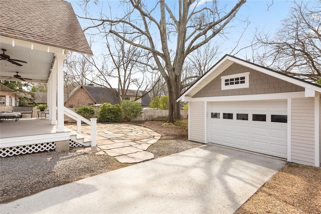 detached garage with ceiling fan, driveway, and fence