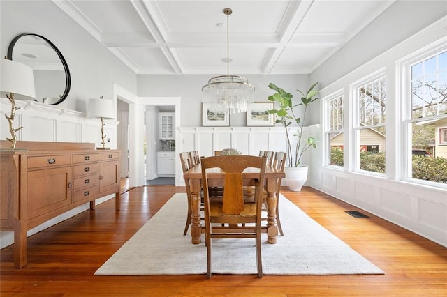 dining area featuring a wealth of natural light, coffered ceiling, and visible vents