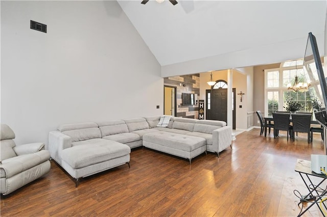 living room featuring ceiling fan with notable chandelier, hardwood / wood-style flooring, and high vaulted ceiling