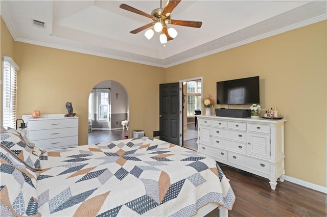 bedroom with multiple windows, ceiling fan, dark hardwood / wood-style flooring, and ornamental molding