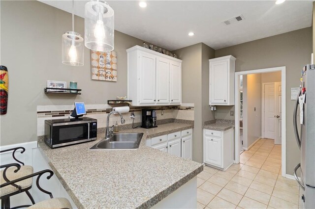 kitchen featuring sink, white cabinetry, kitchen peninsula, and hanging light fixtures