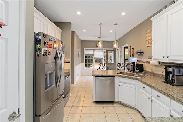 kitchen with backsplash, stainless steel appliances, sink, pendant lighting, and white cabinetry