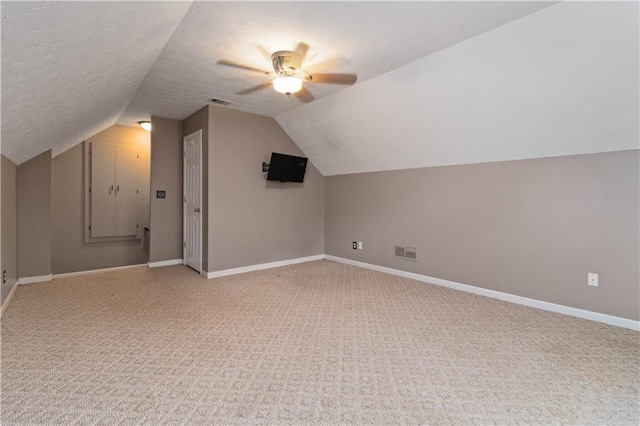 additional living space featuring carpet flooring, a textured ceiling, ceiling fan, and lofted ceiling