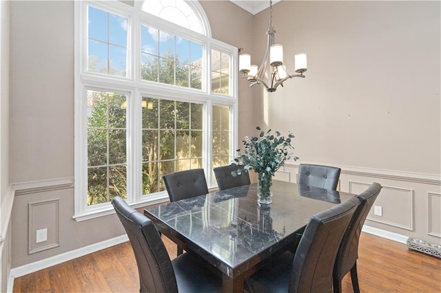 dining room with dark wood-type flooring and an inviting chandelier