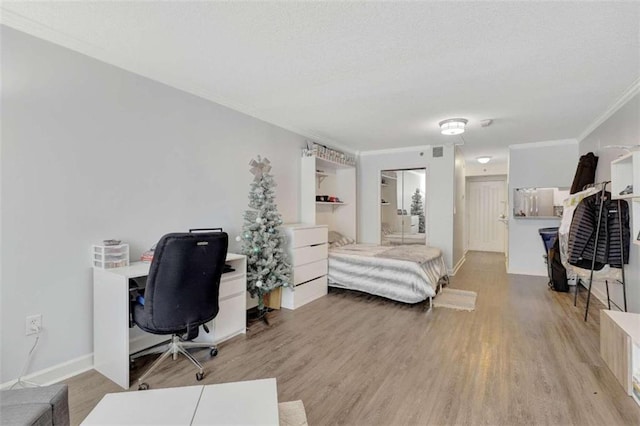 2870 Pharr Ct S Unit 503, Atlanta, GA 30305 - bedroom featuring a desk, crown molding, light wood-type flooring, a textured ceiling, and baseboards