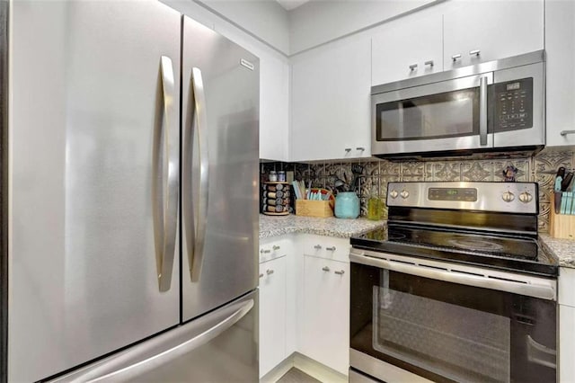2870 Pharr Ct S Unit 503, Atlanta, GA 30305 - kitchen featuring appliances with stainless steel finishes, white cabinetry, backsplash, and light stone countertops