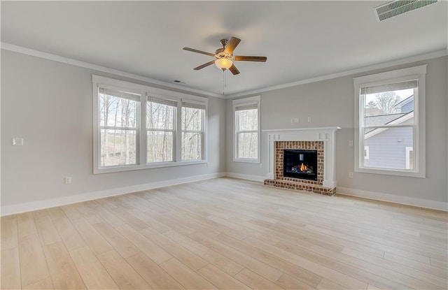 unfurnished living room featuring plenty of natural light, visible vents, and crown molding