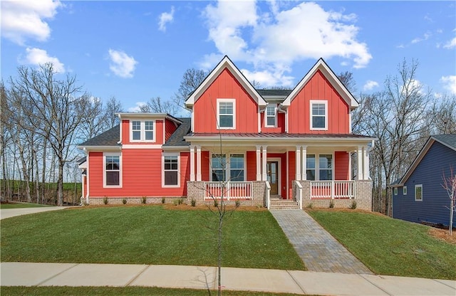 view of front of property with covered porch, board and batten siding, and a front yard