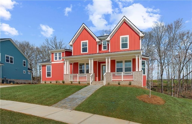 view of front of property with board and batten siding, a front yard, covered porch, and central AC unit