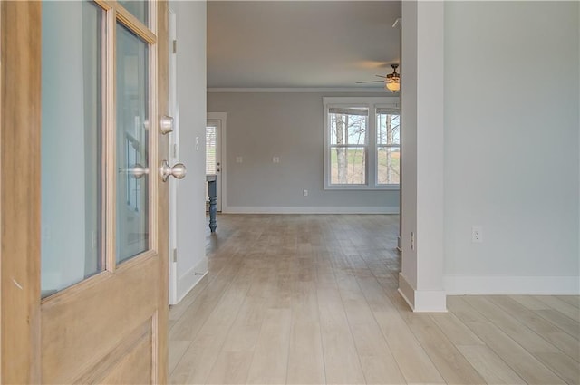 entrance foyer with a ceiling fan, crown molding, light wood-style flooring, and baseboards