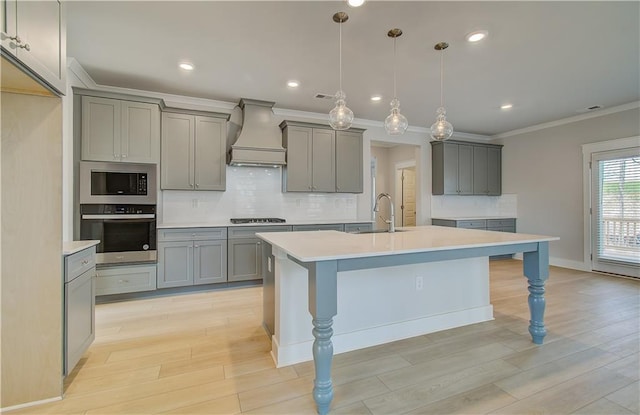 kitchen featuring built in microwave, custom range hood, stainless steel oven, and light countertops