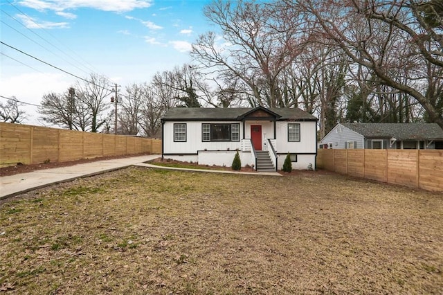 view of front of property featuring fence private yard and a front lawn