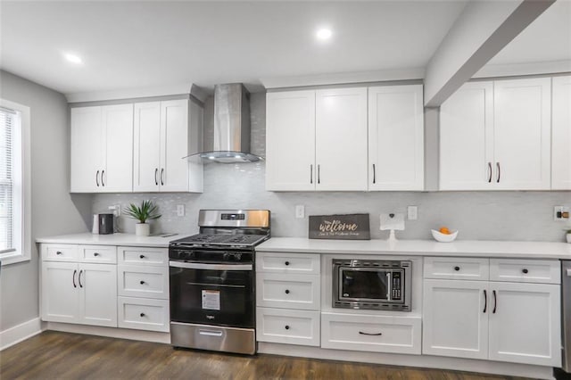 kitchen with wall chimney exhaust hood, appliances with stainless steel finishes, light countertops, and white cabinetry