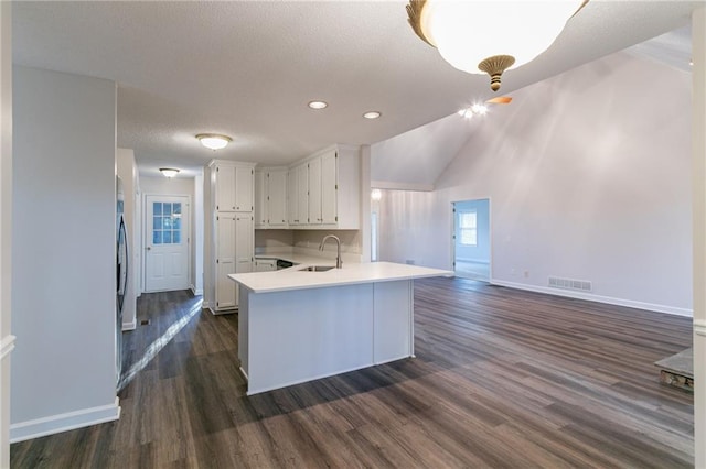 kitchen featuring kitchen peninsula, sink, white cabinets, and dark hardwood / wood-style floors