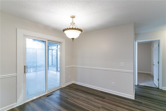 empty room featuring dark wood-type flooring and a textured ceiling