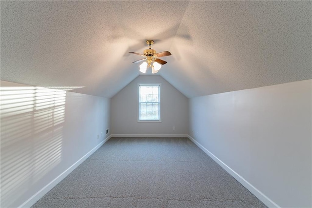 bonus room featuring carpet floors, lofted ceiling, ceiling fan, and a textured ceiling