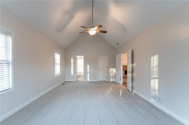 unfurnished living room featuring light carpet, ceiling fan, and lofted ceiling