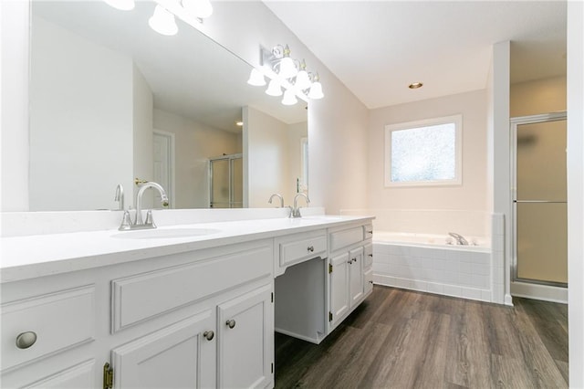 bathroom with vanity, wood-type flooring, and independent shower and bath