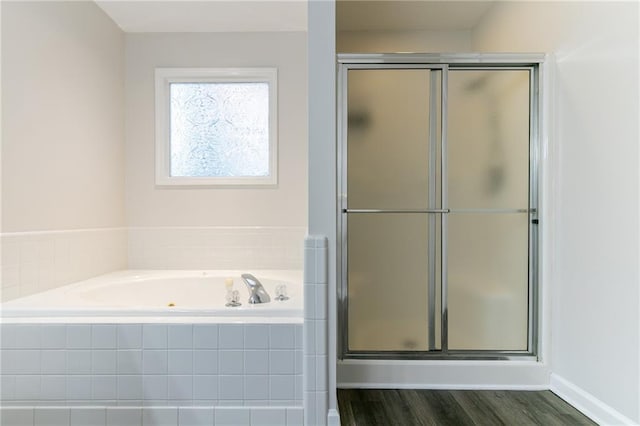 bathroom featuring hardwood / wood-style flooring and plus walk in shower