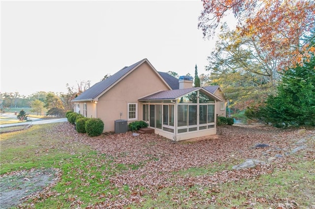 back of house with a sunroom and central AC unit