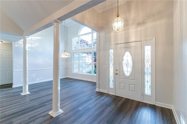 foyer with ornate columns, high vaulted ceiling, dark hardwood / wood-style floors, and an inviting chandelier