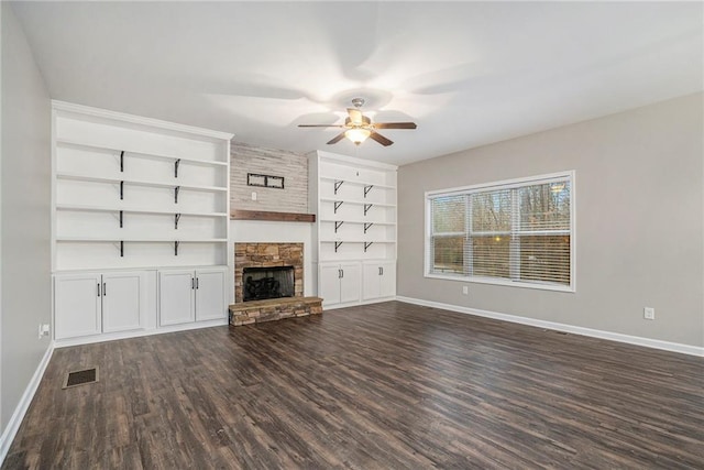 unfurnished living room featuring a stone fireplace, ceiling fan, and dark hardwood / wood-style floors