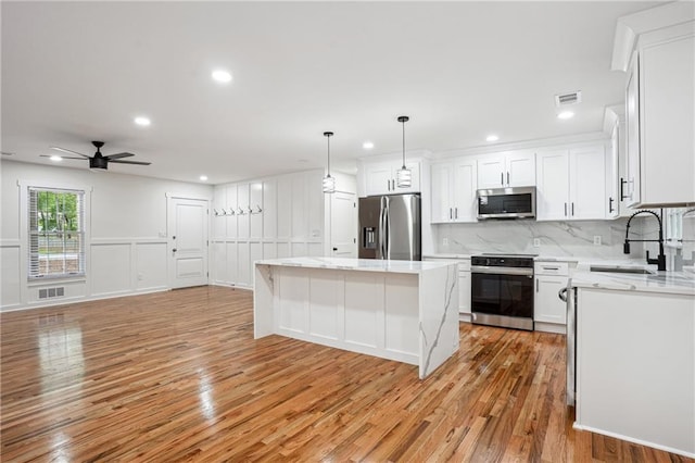 3455 Broxton Mill Way, Snellville, GA 30039 - kitchen featuring stainless steel appliances, a sink, light wood finished floors, a ceiling fan, and tasteful backsplash