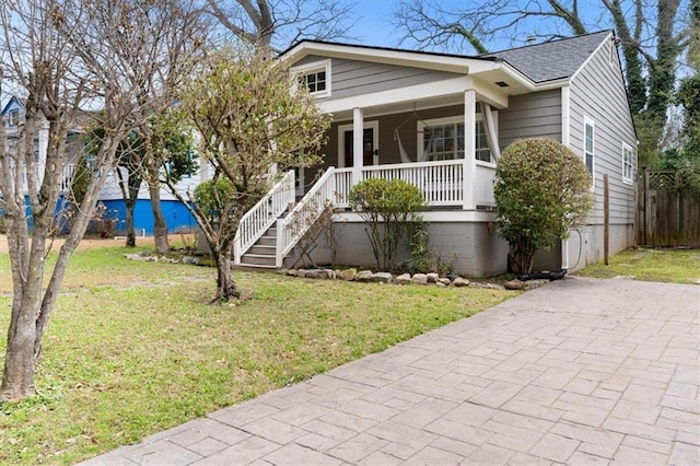 view of front facade with covered porch and a front yard