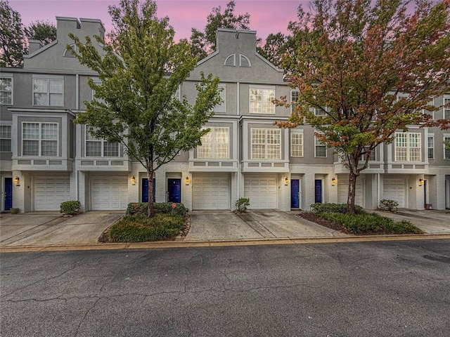 multi unit property featuring driveway and an attached garage