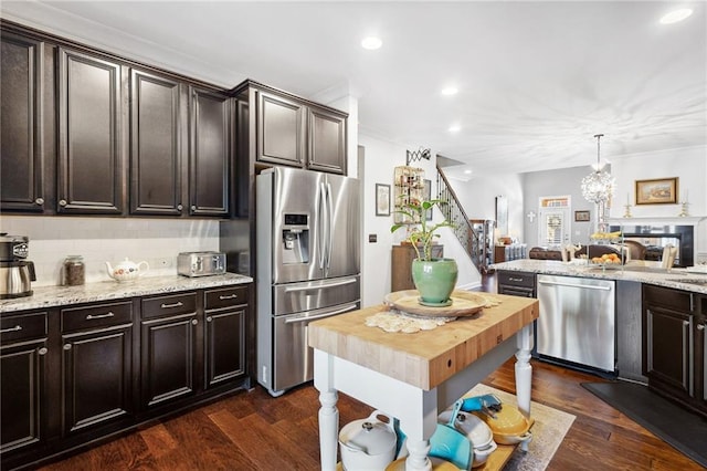 kitchen featuring stainless steel appliances, backsplash, dark brown cabinets, and dark wood-style floors