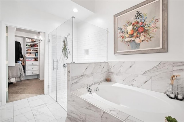 bathroom featuring a stall shower, a spacious closet, marble finish floor, and a bath