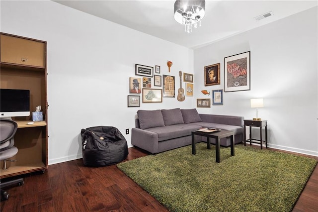 living area with baseboards, visible vents, and wood finished floors