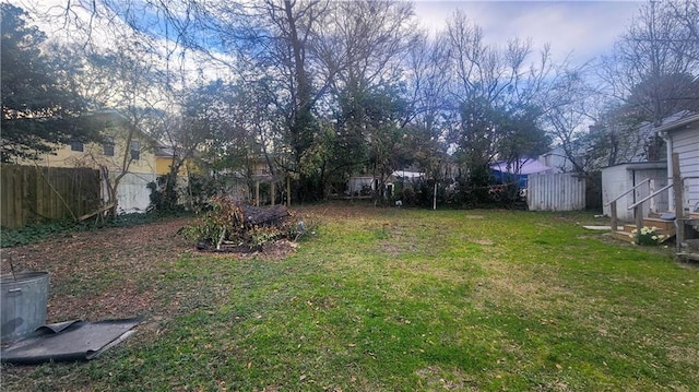 view of yard with an outbuilding, fence, and a shed