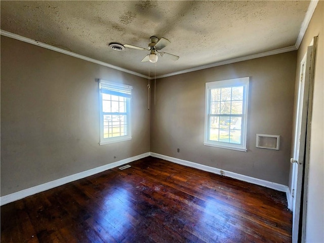 spare room with baseboards, crown molding, visible vents, and wood finished floors