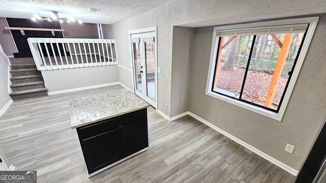 interior space with a textured ceiling and light hardwood / wood-style flooring