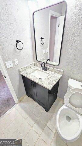 bathroom with tile patterned floors, toilet, and vanity